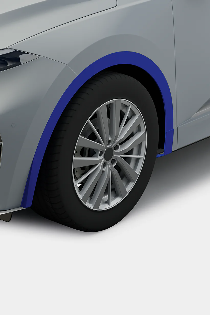 Close-up view of the front left portion of a silver car, featuring detailed headlight design, a blue wheel arch trim secured with tesa tape, and a section of the front bumper and grille. The tire and alloy wheel are visible. (This text has been generated by AI)