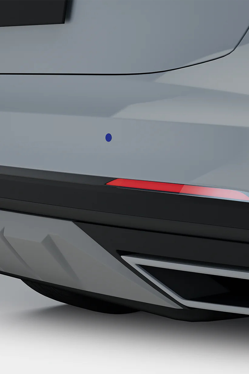 Close-up of a gray cars rear, showing the bumper, tail light, and exhaust. The bumper has a sleek design with sensors visible, and the tail light is illuminated with a red hue. The exhaust features a modern, geometric shape. (This text has been generated by AI)