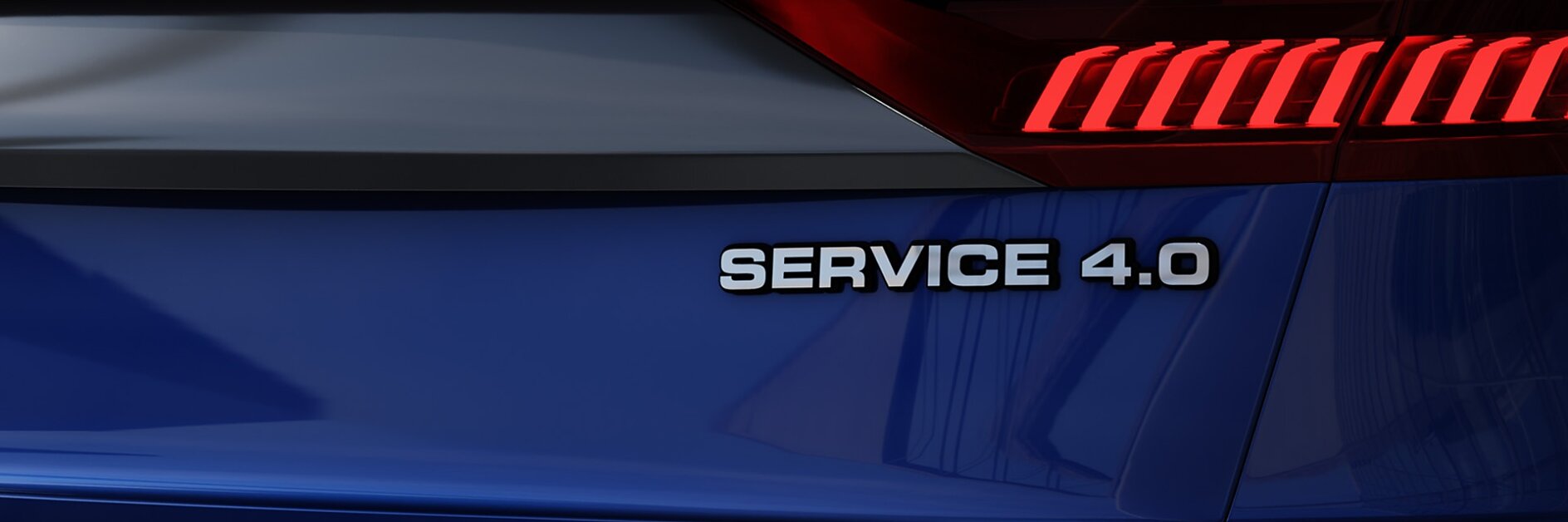 The image shows the rear section of a vehicle with a smooth blue surface. A red light bar spans across the back, and the text SERVICE 4.0 is prominently displayed on the right side. The vehicles details are carefully secured using tesa tape, ensuring a sleek and seamless finish while maintaining its durability and design integrity. (This text has been generated by AI)